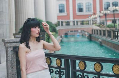 Portrait of woman standing by swimming pool