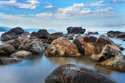 Rocks in sea against sky