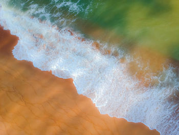 High angle view of waves reaching on shore at beach