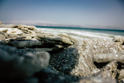 Rock formation on beach against sky