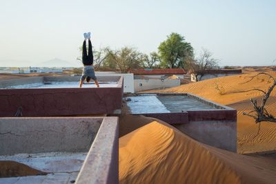 Man doing handstand on rooftop