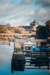 Boats moored in lake against buildings in city