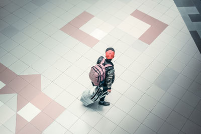 High angle view of young man walking on tiled floor