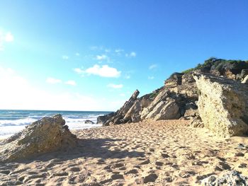 Scenic view of beach against blue sky