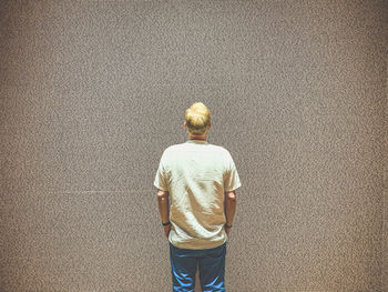 Rear view of man standing by wall