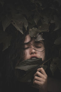 Close-up of woman with eyes closed amidst plants