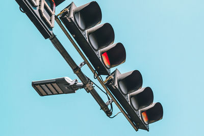 Low angle view of road signal against clear blue sky