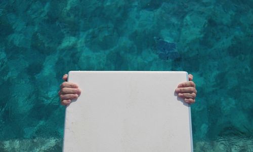 Close-up of hand on swimming pool