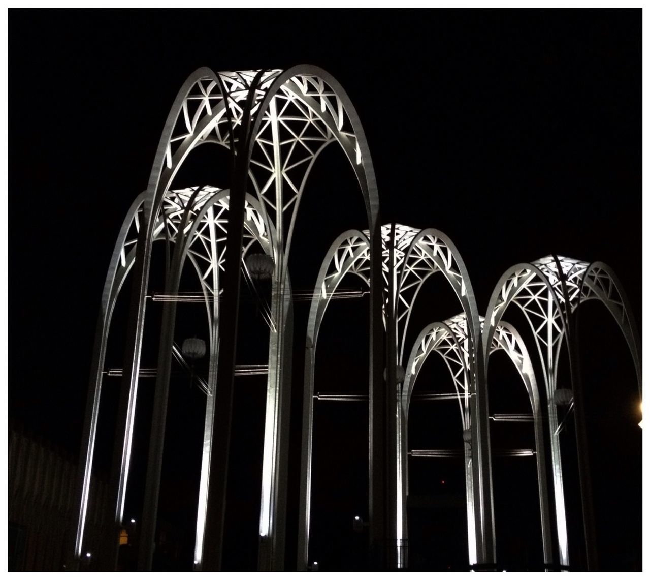 low angle view, transfer print, architecture, built structure, auto post production filter, night, clear sky, arch, illuminated, metal, pattern, repetition, building exterior, no people, copy space, arts culture and entertainment, in a row, outdoors, building, sky