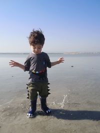 Full length of boy on beach against sky