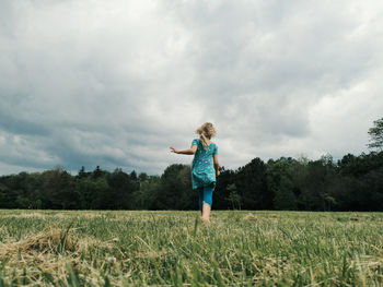 Cute little girl run on meadow. kids girl legs feet in rain boots. freedom innocence and adolescense 