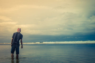 Rear view of man standing on beach