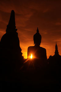 Ancient buddha statue in sukhothai historical park at sunset