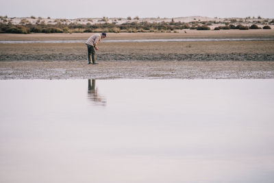 Woman standing on beach against clear sky