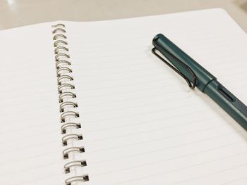 High angle view of pen on spiral notebook