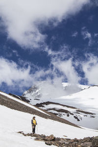 Man standing on snowcapped mountain against sky