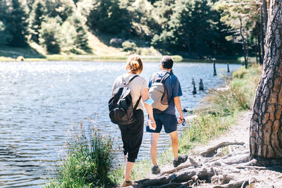 Mature couple walking by a lake with a medical face mask in times of the coronavirus pandemic