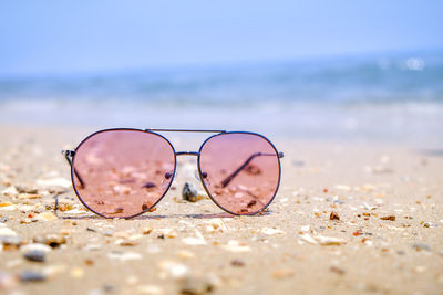 Close-up of sunglasses on beach