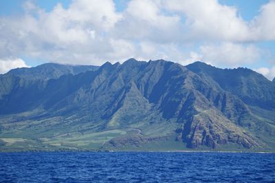 Scenic view of sea and mountains against sky