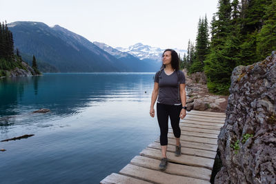 Full length of woman standing on lake against mountains