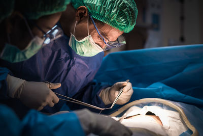 Surgeons operating patient at hospital