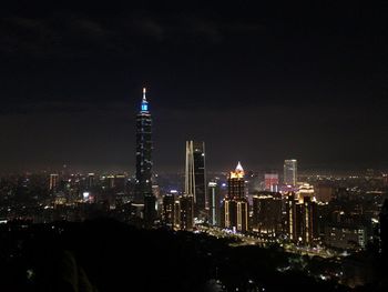 Illuminated buildings against sky at night