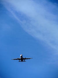 Low angle view of airplane flying against blue sky