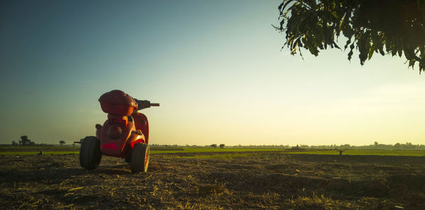 Full length of man sitting on field against clear sky