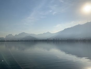 Scenic view of lake by mountains against sky