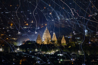 Digital composite image of illuminated buildings in city at night