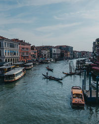 Boats in canal by buildings in city