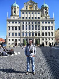 Full length portrait of friends against buildings in city