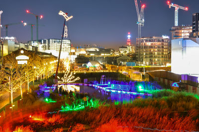 Illuminated city against sky at night