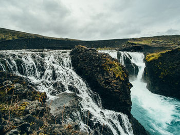 Scenic view of waterfall against sky