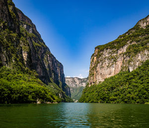 Scenic view of lake and mountains against clear sky