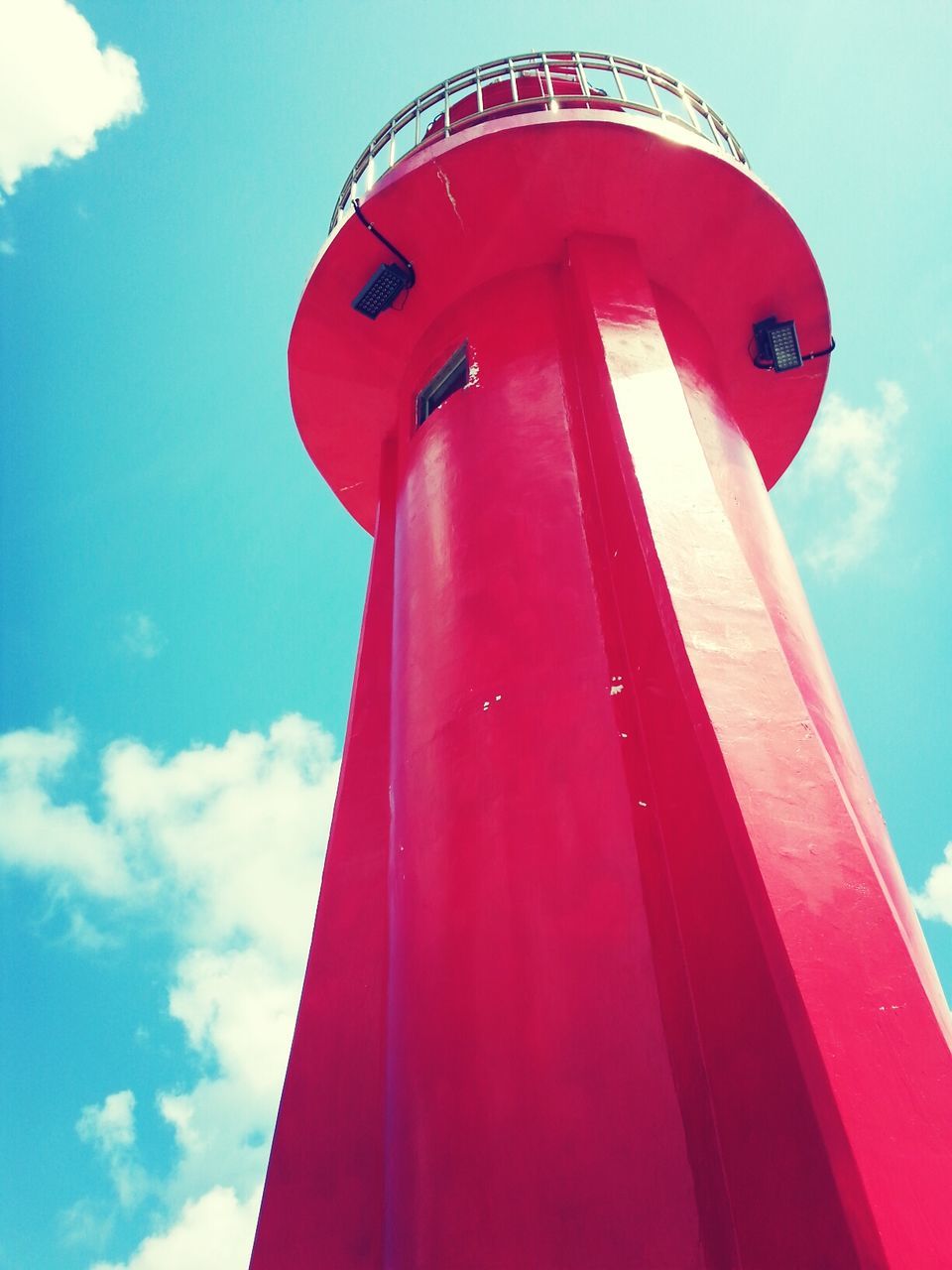 red, low angle view, built structure, architecture, sky, lighthouse, building exterior, protection, sunlight, guidance, safety, blue, day, tower, outdoors, no people, security, cloud - sky, metal, cloud