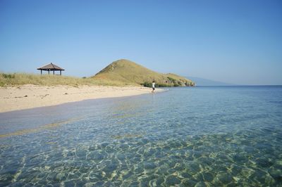 Scenic view of beach against clear blue sky