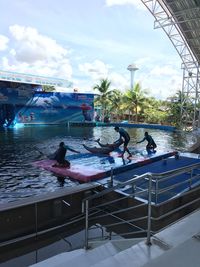 People at swimming pool against sky