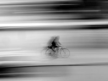 Blurred motion of man riding bicycle