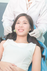 Midsection of dentist examining smiling woman