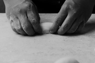 Cropped hands of person kneading dough