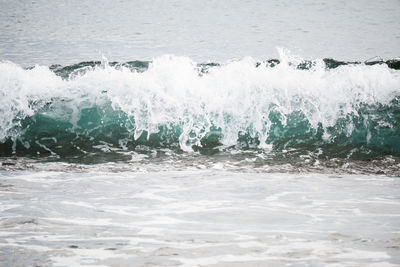 Waves splashing on shore during sunny day