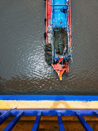 Top view of a boat moving with leaves on the river. view from the bridge.
