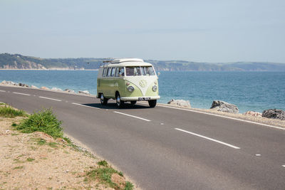 View of road by sea against clear sky