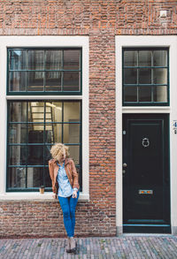 Full length of woman standing against window