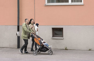 Man and woman on bicycle against building