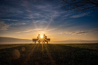 Lifeguard hut on field against sky during sunset