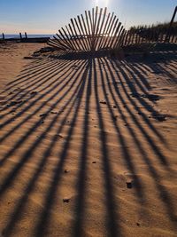 Shadow on sand at beach against sky
