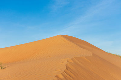 Scenic view of desert against blue sky