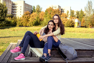 Portrait of woman sitting on bench in park